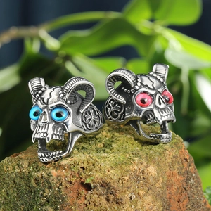 Gothic punk stainless steel ram skull rings with red and blue gem eyes on a stone base