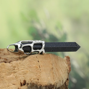Détail d'un pendentif hexagonal en grès bleu sur base en maille argentée sur écorce