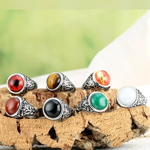Retro men's silver rings set with diverse oval gemstones on natural cork background