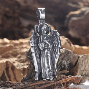 Pendentif ailes d'ange vintage en argent vieilli sur un fond en bois naturel