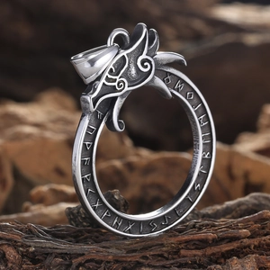 Close-up of vintage dragon head pendant with Norse runes on round stainless steel ring