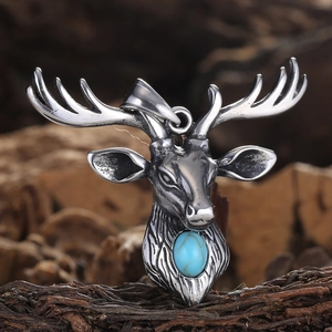 Vintage silver elk deer head pendant with blue gemstone on rustic wood background