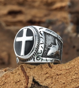 Macro shot of vintage stainless steel cross ring with black enamel disk and detailed engravings