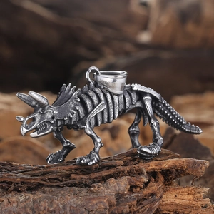 Macro shot of silver triceratops skeleton pendant with fossil details on bark background