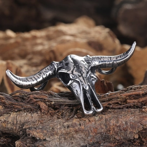 Vintage titanium steel bison skull pendant with retro finish on natural bark background