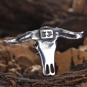 Vintage stainless steel buffalo skull pendant with polished silver finish on rustic wood