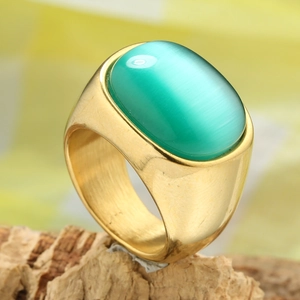 Bague vintage dorée avec une grande pierre œil de tigre verte sur un fond en bois naturel