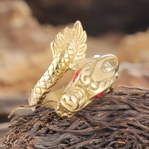 Macro detail of golden dragon head ring with ruby eyes and intricate scale texture