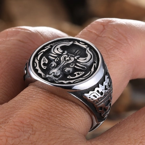 Macro detail of men's vintage bull head ring in stainless steel worn on finger