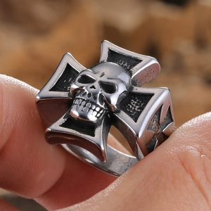 Macro shot of vintage skull and iron cross ring with aged stainless steel texture