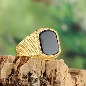 Detailed macro view of a vintage men's gold ring with a large rectangular black onyx stone