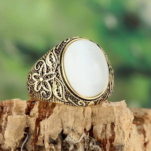 Dettaglio ravvicinato di anello vintage in titanio dorato con pietra ovale occhio di gatto
