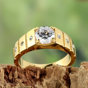 Vue détaillée d'une large bague dorée vintage avec zircon sur une écorce naturelle