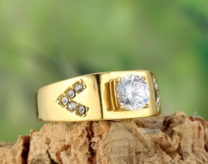 Vue macro d'une bague large dorée avec un grand cristal et des pierres latérales en V