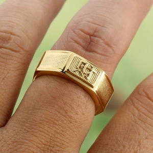 Close-up of golden signet ring for men featuring a traditional Chinese fortune character