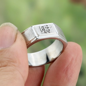 Macro shot of silver ring with Chinese Cai character engraving and matte texture