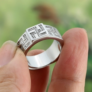 Macro shot of vintage silver stainless steel ring with engraved Buddhist swastika patterns