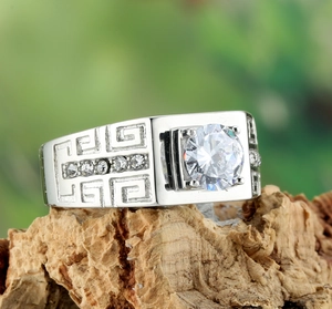 Macro shot of silver titanium ring with Greek Key pattern and large center gemstone