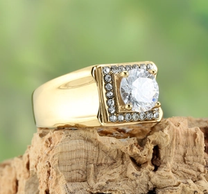 Détail macro d'une bague dorée avec pierre ronde et halo de diamants de taille carrée
