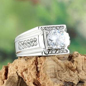Détail macro d'une bague en acier pour homme avec grand zircon sur socle en bois