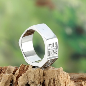 Silver square-top stainless steel ring with vintage religious symbols on wood base