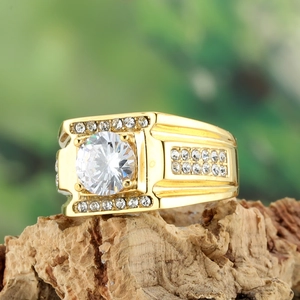 Vue macro détaillée d'une bague pour homme en or avec un grand zircon sur bois naturel