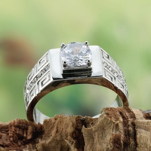 Macro shot of silver men's titanium ring featuring Greek meander pattern and a large zircon