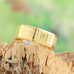 Gold-plated ring with Chinese character for wealth on a rustic wooden base