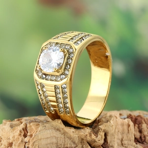 Luxurious gold-plated wedding ring with a large round cubic zirconia on wood background