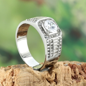 Macro side view of silver halo men's ring with large round zircon on wood base