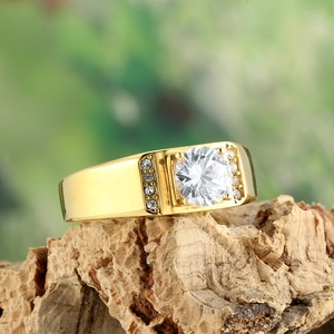 Macro shot of gold-plated titanium steel ring with a large zircon on a wooden stand
