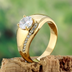 Détail macro d'une bague en acier titane doré avec un zircon ovale et sertissage