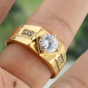 Macro shot of gold wide band ring with a large round cubic zirconia in 4-prong setting