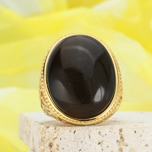Macro detail of vintage gold ring with large oval black gemstone and cat eye effect