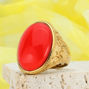 Macro detail of retro gold ring featuring a large oval red gemstone and embossed patterns