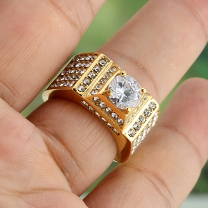 Close-up of a men's gold square ring featuring a large center diamond and pave accents