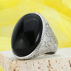 Vintage silver ring with oval black stone and engraved vine pattern on stone base