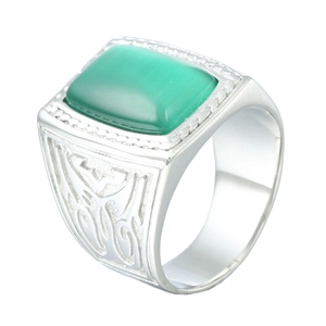 Macro detail of silver stainless steel ring with green gemstone and tribal engravings