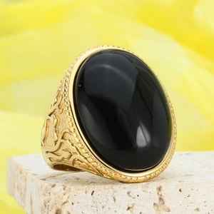 Retro gold ring with a large oval black gemstone and vintage floral carvings on stone