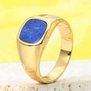 Macro shot of men's vintage gold ring featuring an inlaid blue lapis lazuli stone