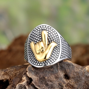 Detail of punk style two-tone ring with golden gesture relief on a bark base