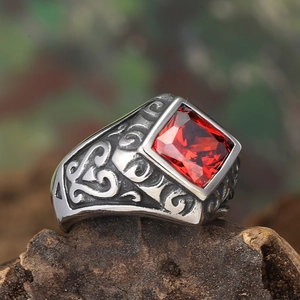 Macro shot of vintage titanium steel ring featuring red square gemstone and floral engraving