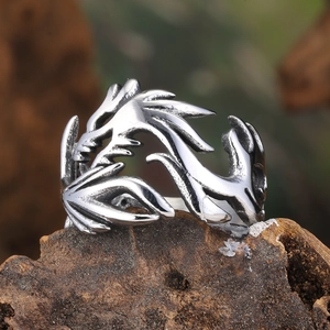 Gros plan de la bague dragon punk ajourée sur socle en bois avec fond flou naturel