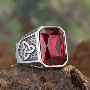 Close-up of vintage Viking Celtic ring with red gemstone on a natural bark background