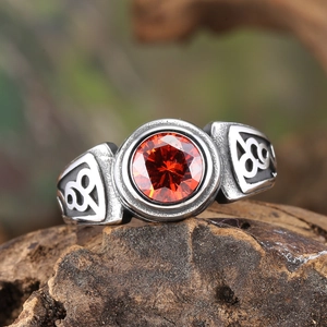 Macro shot of vintage steel ring with orange gemstone and Celtic knots on wood