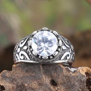 Macro shot of a vintage titanium steel ring featuring floral carving and a clear zircon stone