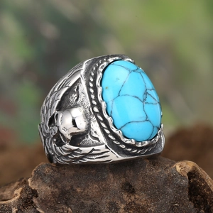 Macro detail of men's vintage steel ring showing the turquoise stone and eagle relief