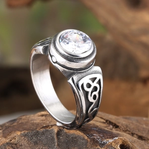 Macro view of vintage steel ring with round zircon and Celtic knot carving