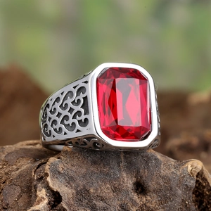 Macro view of vintage titanium steel ring featuring red emerald-cut stone and scrollwork