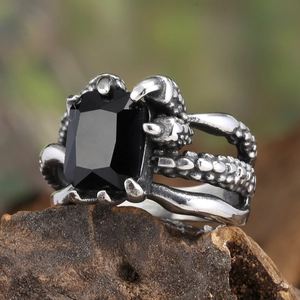 Macro shot of gothic claw ring with large rectangular black gemstone and scale texture
